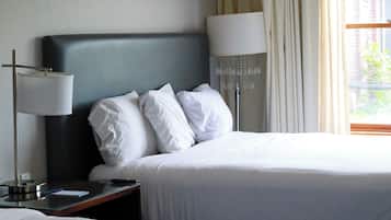 Habitación de hotel con dos camas, una gran obra de arte abstracto en la pared y vistas al exterior a través de la ventana.