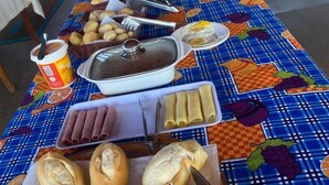 Une table de buffet garnie de divers plats et recouverte d’une nappe à carreaux.