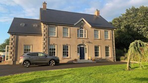 Une maison à deux étages avec une allée et une voiture garée.
