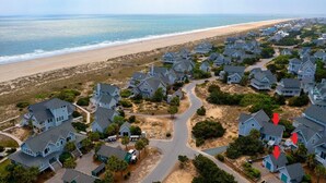 Zona residencial à beira-mar, com casas, praia e estrada.