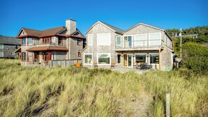 Une maison à deux étages avec un grand garage et un espace extérieur aménagé avec une zone salon couverte.