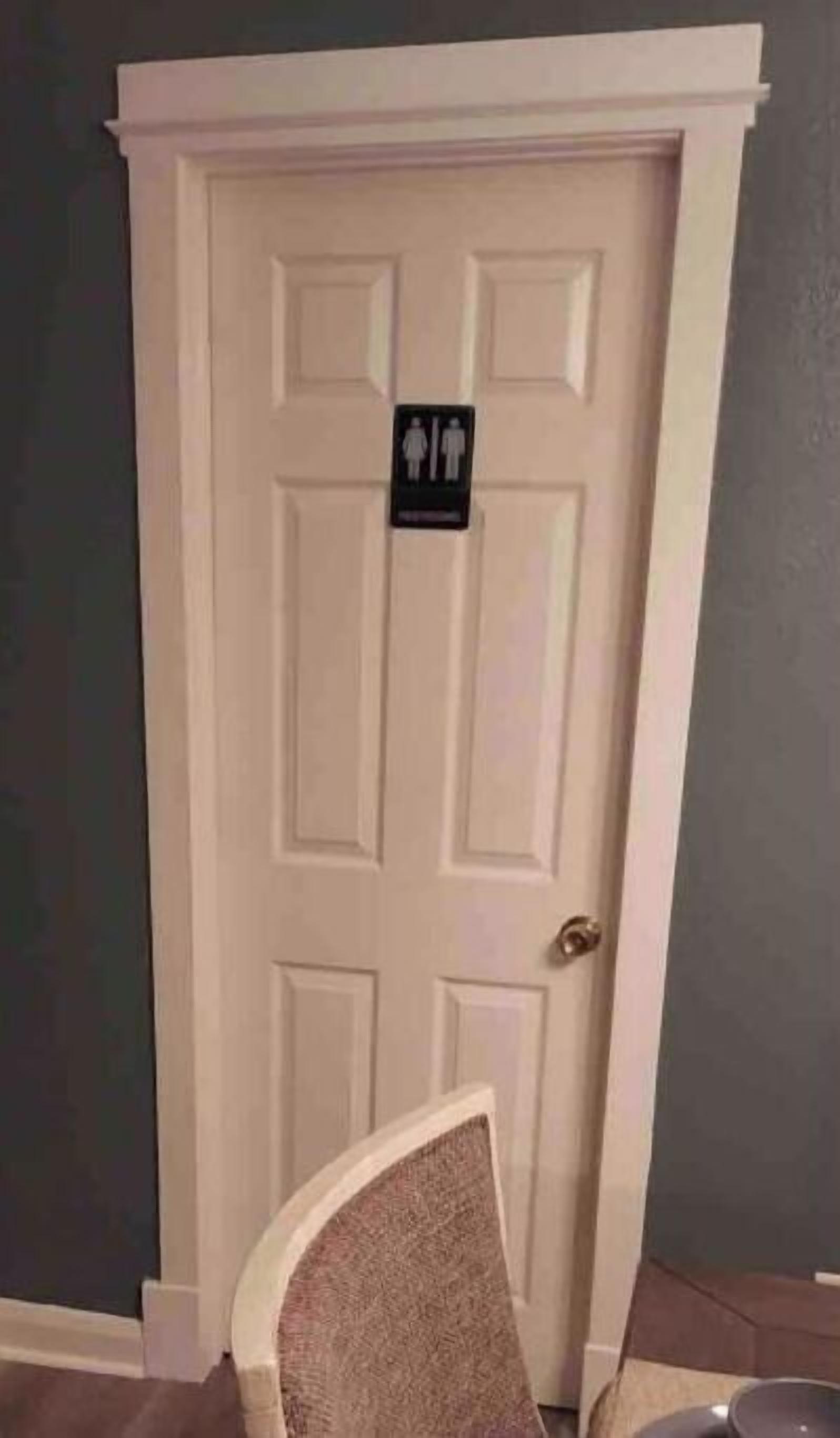 A white door with a gender-neutral restroom sign.