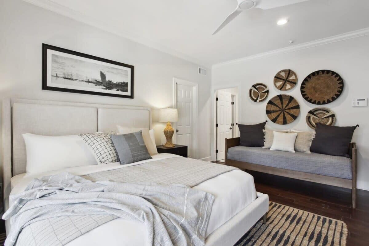Een slaapkamer met een bed, nachtkastjes, een sofa en wanddecoratie.