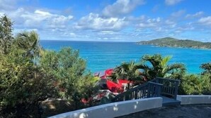 A coastal view with a clear sky, a staircase leading to a building, and a body of water in the background. - Villa Mangorosa (St Thomas)