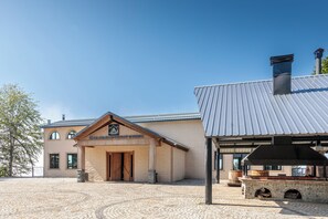A building with a stone facade, a wooden entrance, and a chimney. - Chalet Kvirike (Kobuleti)