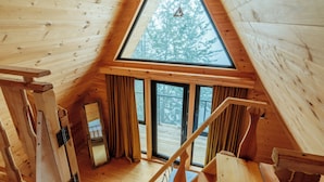A wooden cabin with a triangular roof, large windows, and a wooden staircase. - Chalet Kvirike (Kobuleti)