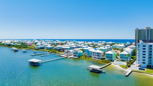 A coastal resort with multiple buildings, docks, and a large body of water. - Lagoon Front | Pet Friendly | Deeded Beach Access, Pool & Pier (Gulf Shores)