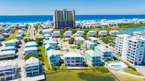 A coastal resort area with multiple buildings, including a prominent hotel with a red roof, surrounded by smaller structures and a beach. - Lagoon Front | Pet Friendly | Deeded Beach Access, Pool & Pier (Gulf Shores)