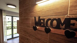 A wooden wall with a 'WELCOME' sign and heart-shaped decorations. - Three-room apartment with garden (Pont-Saint-Martin)