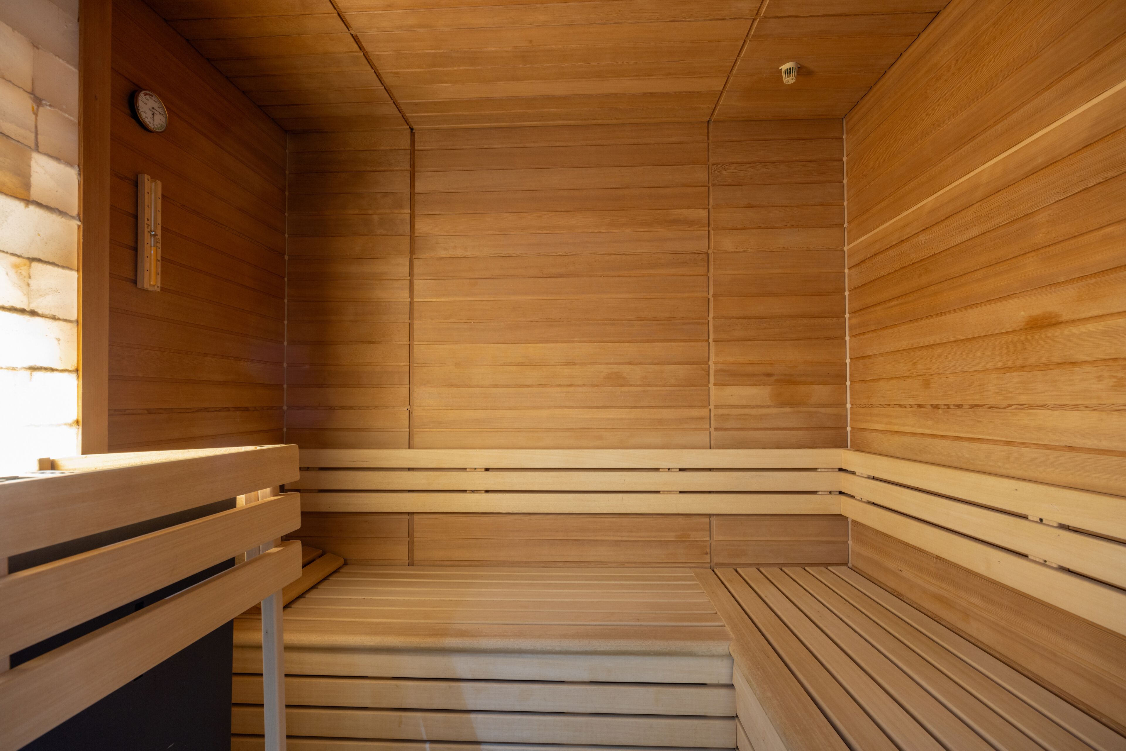 Un sauna avec des murs et des bancs en bois.
