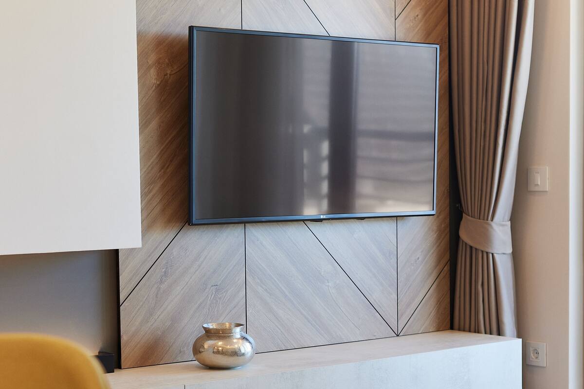 Ein modernes Wohnzimmer mit einem an einer Holzwand befestigten Flachbildfernseher.