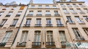 A multi-story building with a classic architectural style, featuring balconies with wrought iron railings and a uniform facade.