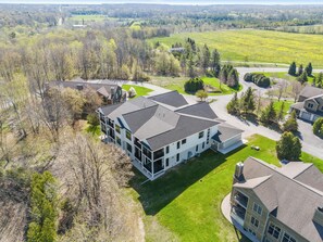 Un quartier résidentiel avec des maisons modernes, de belles pelouses verdoyantes et un ciel dégagé.
