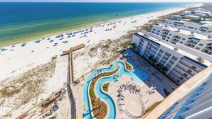 A resort with a pool area, beach access, and a view of the ocean.