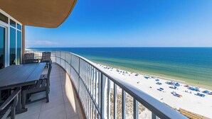 A balcony with a view of a beach and ocean.