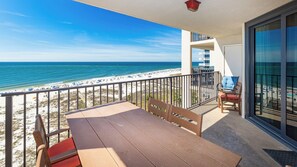 A balcony with a view of the beach and ocean.
