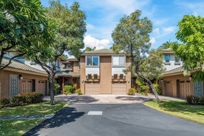 A residential area with two-story houses, a paved driveway, and well-maintained lawns.