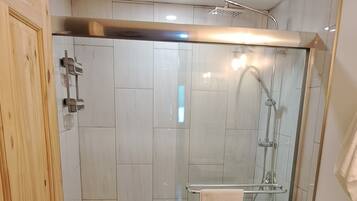 Ein Badezimmer mit Dusche, Toilette und Waschtisch.