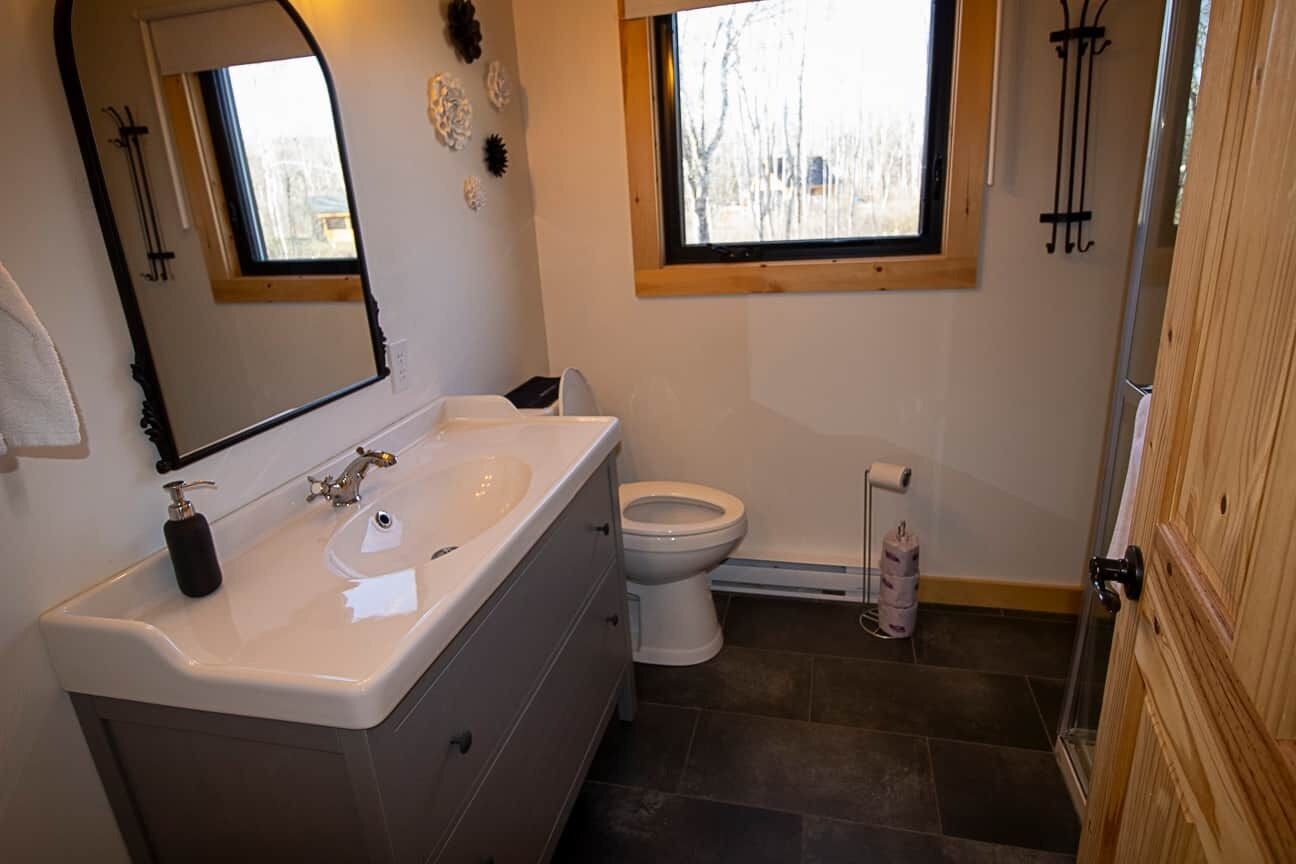 Ein Badezimmer mit einem weißen Waschbecken, einer Toilette und einem Fenster.