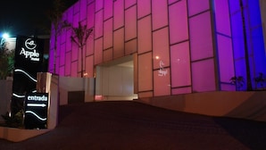 The exterior of the Apple Motel with a modern design, featuring a large entrance and a sign indicating the direction to the entrance. - Apple Motel - Adults Only (São Paulo)