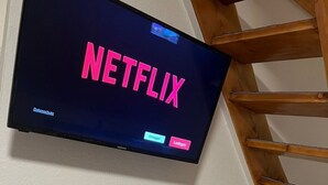 Un téléviseur à écran plat fixé au mur, sur lequel apparaît le logo de Netflix.
