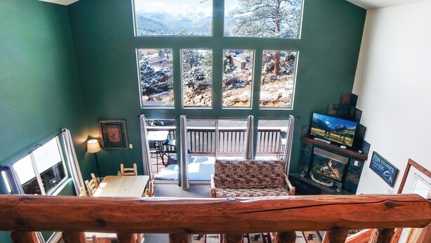 A spacious room with large windows, a ceiling fan, and a view of a snowy landscape. - Lazy R Cottages: 16a 2 Bedroom Cabin (Estes Park)