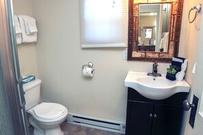 A bathroom with a toilet, a sink, and a mirror. - Triple R Cottages: 2 1 Bedroom Cabin (Estes Park)