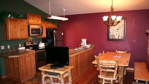 A compact kitchen with wooden cabinets, a microwave, a stove, and a sink. - Lazy R Cottages: 17 2 Bedroom Cabin (Estes Park)