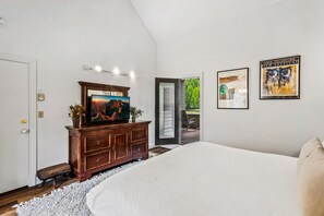 Une chambre à coucher avec un lit, une commode et des œuvres d’art accrochées au mur.