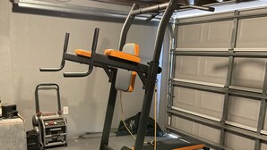 Una palestra domestica con una sbarra per trazioni, una panca e una macchina per pesi.