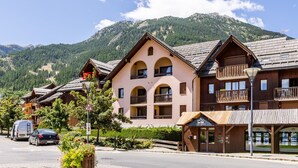 Un chalet de montagne doté de plusieurs balcons et offrant une vue imprenable sur les montagnes.