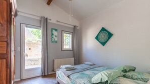 Une chambre à coucher avec un lit, une fenêtre, un radiateur et une porte.