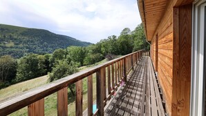 A wooden deck with a view of a forested hillside. - La Bergerie du Pré de l'Orme - Avec vue montagne (La Bresse)