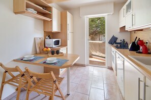 Prepare meals in the central island kitchen, featuring a microwave and sink, and dine at the adjacent table.