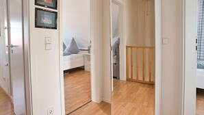 Ein Schlafzimmer mit einem Bett, einem Nachttisch und einer Holztür.