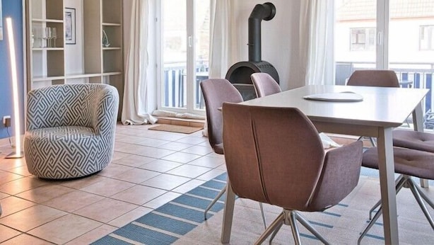 Ein modernes Wohnzimmer mit Essbereich, einer eingebauten Bücherwand und einem Kamin.