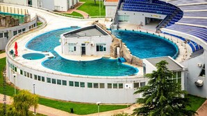 Une grande piscine intérieure divisée en plusieurs zones et dotée d’un bâtiment central.