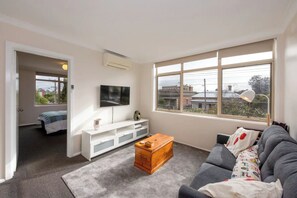 Apartamento básico, 1 cama Queen | Área de estar | TV