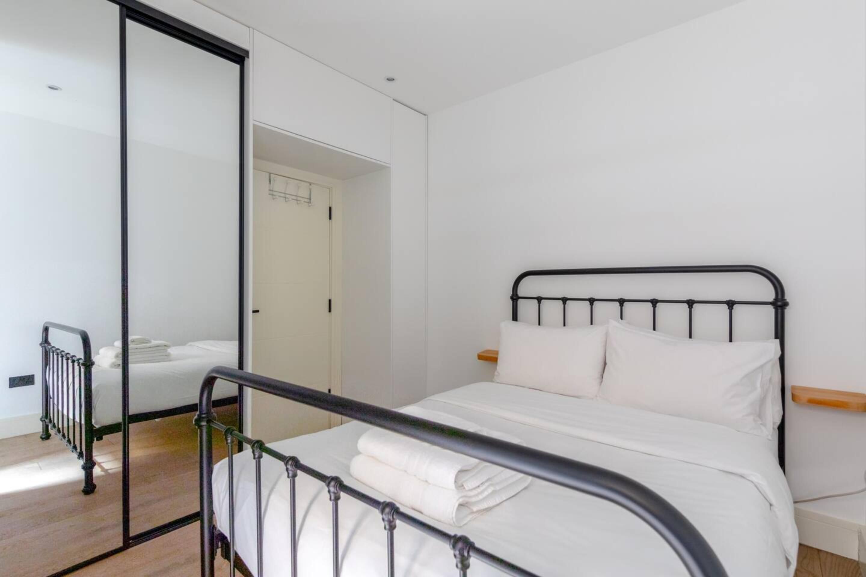 Un dormitorio con cama, radiador y puerta corredera.