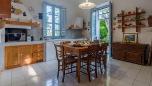 Une cuisine spacieuse dotée d’un îlot central, de meubles en bois et d’un coin repas avec des chaises.