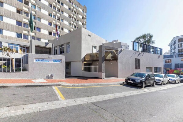 A modern building with a parking area and a sign indicating reserved parking.
