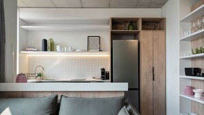 A modern kitchen with a built-in refrigerator, white cabinetry, and a countertop with various kitchen items. - Six on N 302 (Cape Town)