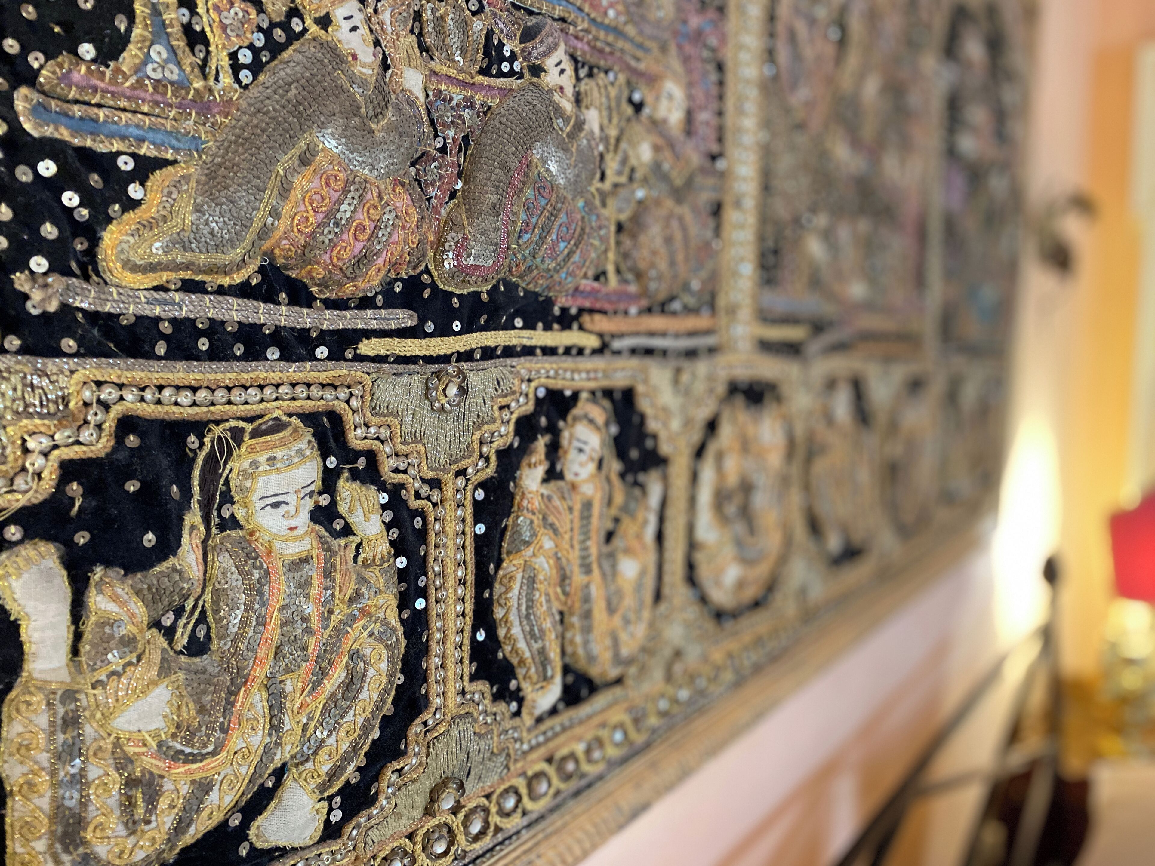 Un tapiz detallado con diseños y figuras intrincadas, probablemente parte de una exposición histórica o cultural.