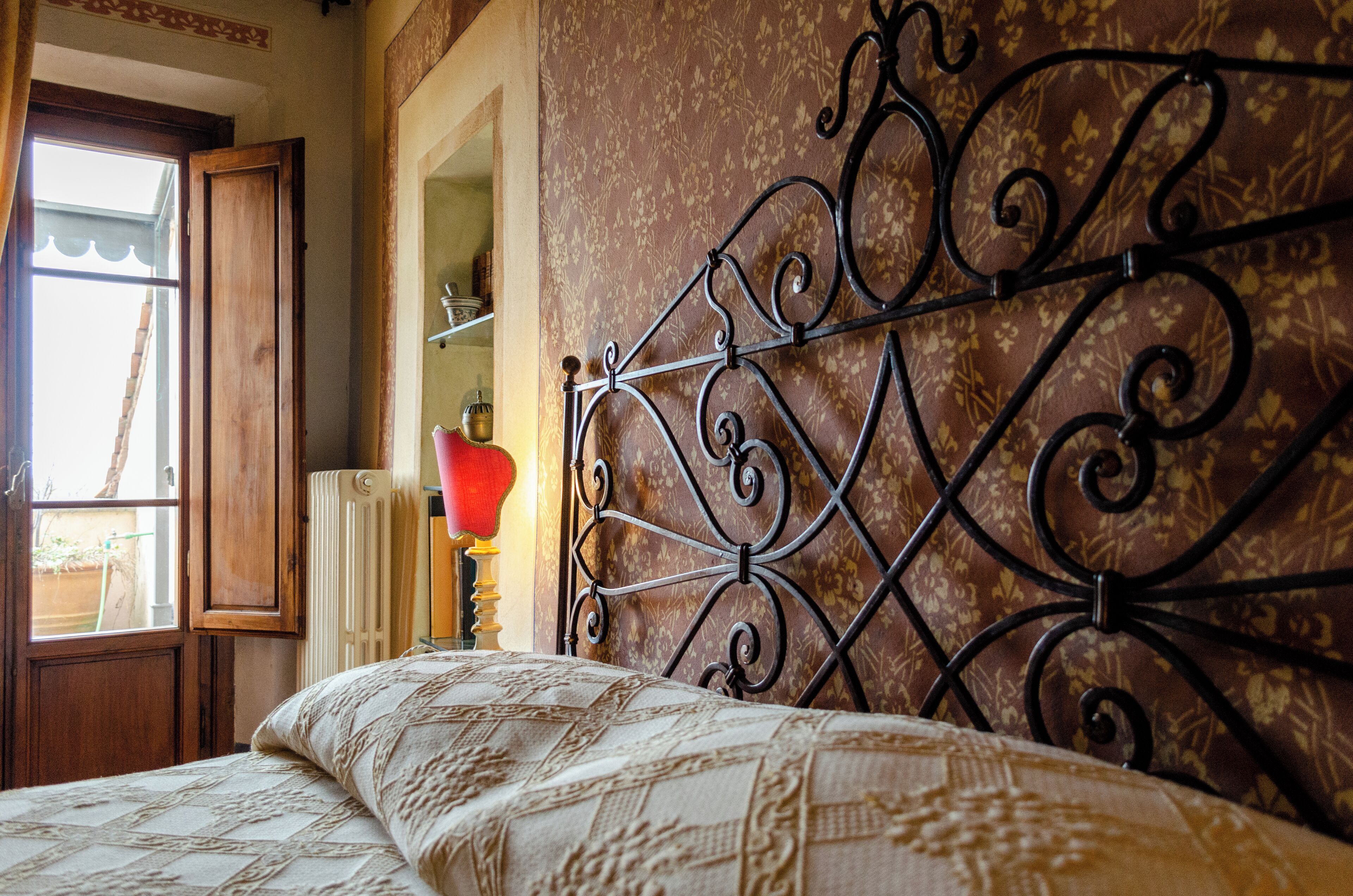 A bedroom with a bed, a window, and a radiator.