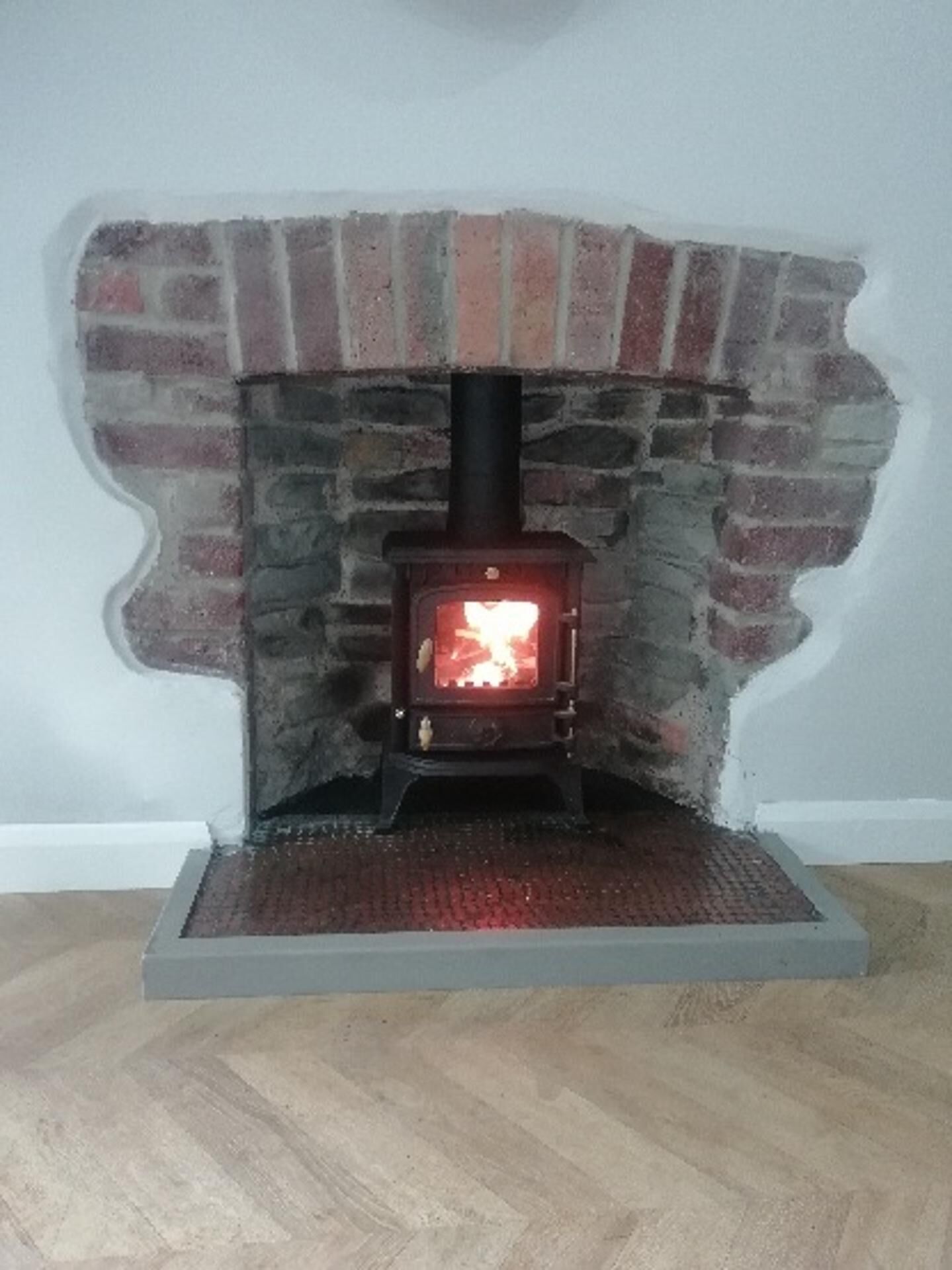 A fireplace with a brick surround and a black chimney.