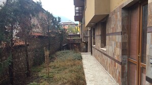 Un sendero estrecho que lleva a un edificio con paredes de piedra y una puerta de madera.