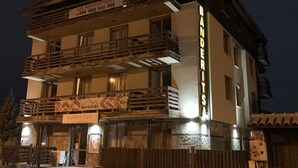 Un edificio de varios pisos con un letrero que dice 'Banderitsa' y un número de teléfono para reservas.