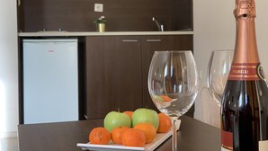Una cocina con armarios de madera oscura, una encimera blanca y una botella de champán Fiolelli.