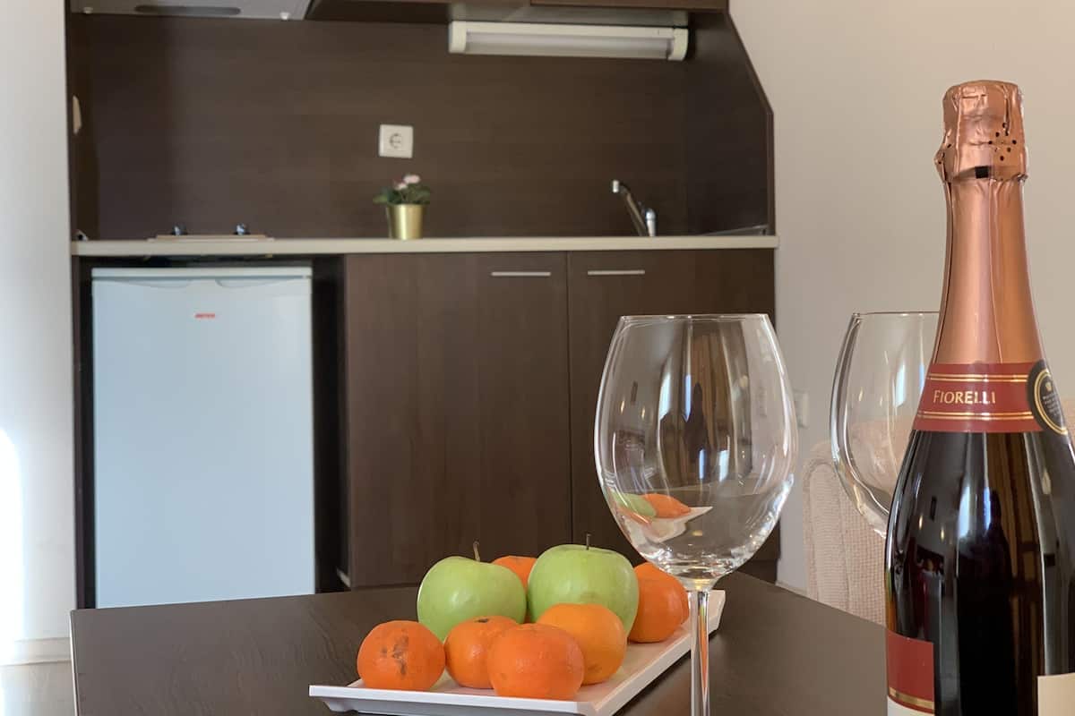 A kitchen with dark wooden cabinets, a white countertop, and a bottle of Fiolelli champagne.