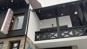 Un hotel con un cartel de estación de esquí, un letrero de habitación y un logotipo en la fachada.